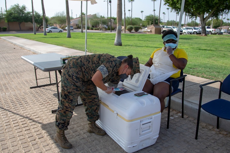 U.S. Marines and Saliors with Headquarters and Headquarters Squadron (H&HS) distribute popsicles and bubbles to service memebers and their families at the Chapel parking lot on Marine Corps Air Station (MCAS) Yuma, Ariz., Sept. 18, 2020. The event was to boost morale among the serivce members and their members families aboard MCAS Yuma.  (U.S. Marine Corps photo by Lance Cpl. Gabrielle Sanders)