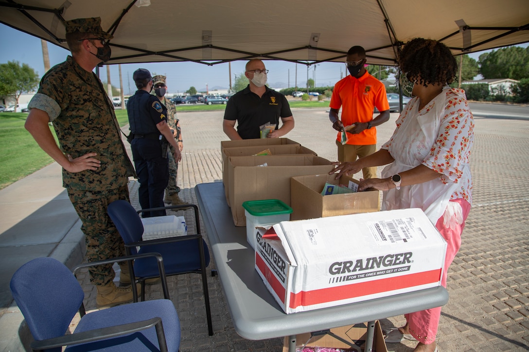 U.S. Marines and Saliors with Headquarters and Headquarters Squadron (H&HS) distribute popsicles and bubbles to service memebers and their families at the Chapel parking lot on Marine Corps Air Station (MCAS) Yuma, Ariz., Sept. 18, 2020. The event was to boost morale among the serivce members and their members families aboard MCAS Yuma.  (U.S. Marine Corps photo by Lance Cpl. Gabrielle Sanders)