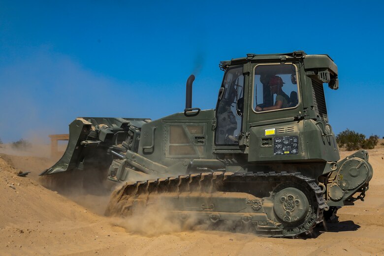 U.S. Marine Corps Lance Cpl Edgar Barragan, a heavy equipment operator, with Marine Wing Support Squadron (MWSS) 371, clears dirt for a fuel containment berm to condut fueling operations at Cannon Air Defense Complex, at Yuma, Ariz., October 19, 2020. Fuel containment berms hold oil, fuel, and other hazardous materials in order to prevent the pollution of soil and water.  (U.S. Marine Corps photo by LCpl. Gabrielle Sanders)