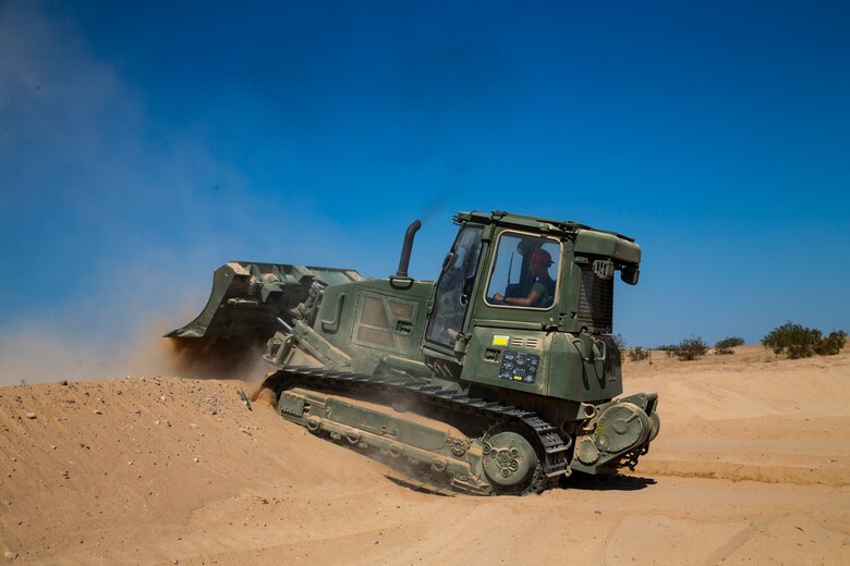 U.S. Marine Corps Lance Cpl Edgar Barragan, a heavy equipment operator, with Marine Wing Support Squadron (MWSS) 371, clears dirt for a fuel containment berm to condut fueling operations at Cannon Air Defense Complex, at Yuma, Ariz., October 19, 2020. Fuel containment berms hold oil, fuel, and other hazardous materials in order to prevent the pollution of soil and water.  (U.S. Marine Corps photo by LCpl. Gabrielle Sanders)
