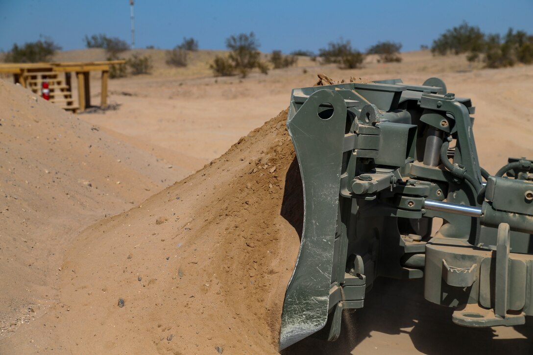 U.S. Marine Corps Lance Cpl Edgar Barragan, a heavy equipment operator, with Marine Wing Support Squadron (MWSS) 371, clears dirt for a fuel containment berm to condut fueling operations at Cannon Air Defense Complex, at Yuma, Ariz., October 19, 2020. Fuel containment berms hold oil, fuel, and other hazardous materials in order to prevent the pollution of soil and water.  (U.S. Marine Corps photo by LCpl. Gabrielle Sanders)