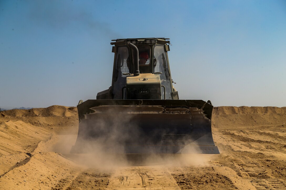 U.S. Marine Corps Lance Cpl Edgar Barragan, a heavy equipment operator, with Marine Wing Support Squadron (MWSS) 371, clears dirt for a fuel containment berm to condut fueling operations at Cannon Air Defense Complex, at Yuma, Ariz., October 19, 2020.