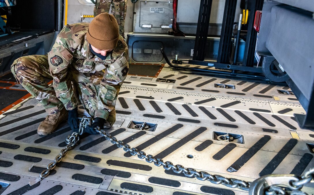 Staff Sgt. Jared Soucy, 3rd Airlift Squadron loadmaster, ties a Delaware Army National Guard trailer to a C-17 Globemaster III during joint training at Dover Air Force Base, Delaware, March 29, 2021. The training focused on providing rapid global airlift through the integration of U.S. Air Force Airmen and Delaware National Guard Soldiers. (U.S. Air Force photo by Senior Airman Christopher Quail)