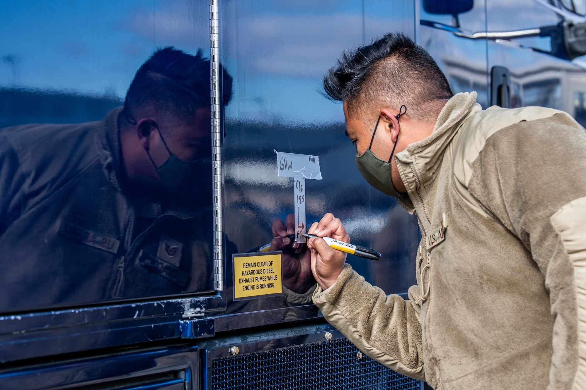 Tech. Sgt. Steven Chaco, 56th Aerial Port Squadron special handling supervisor, writes the center of balance marking on a Delaware Army National Guard truck during joint training at Dover Air Force Base, Delaware, March 29, 2021. The training focused on providing rapid global airlift through the integration of U.S. Air Force Airmen and Delaware National Guard Soldiers. (U.S. Air Force photo by Senior Airman Christopher Quail)