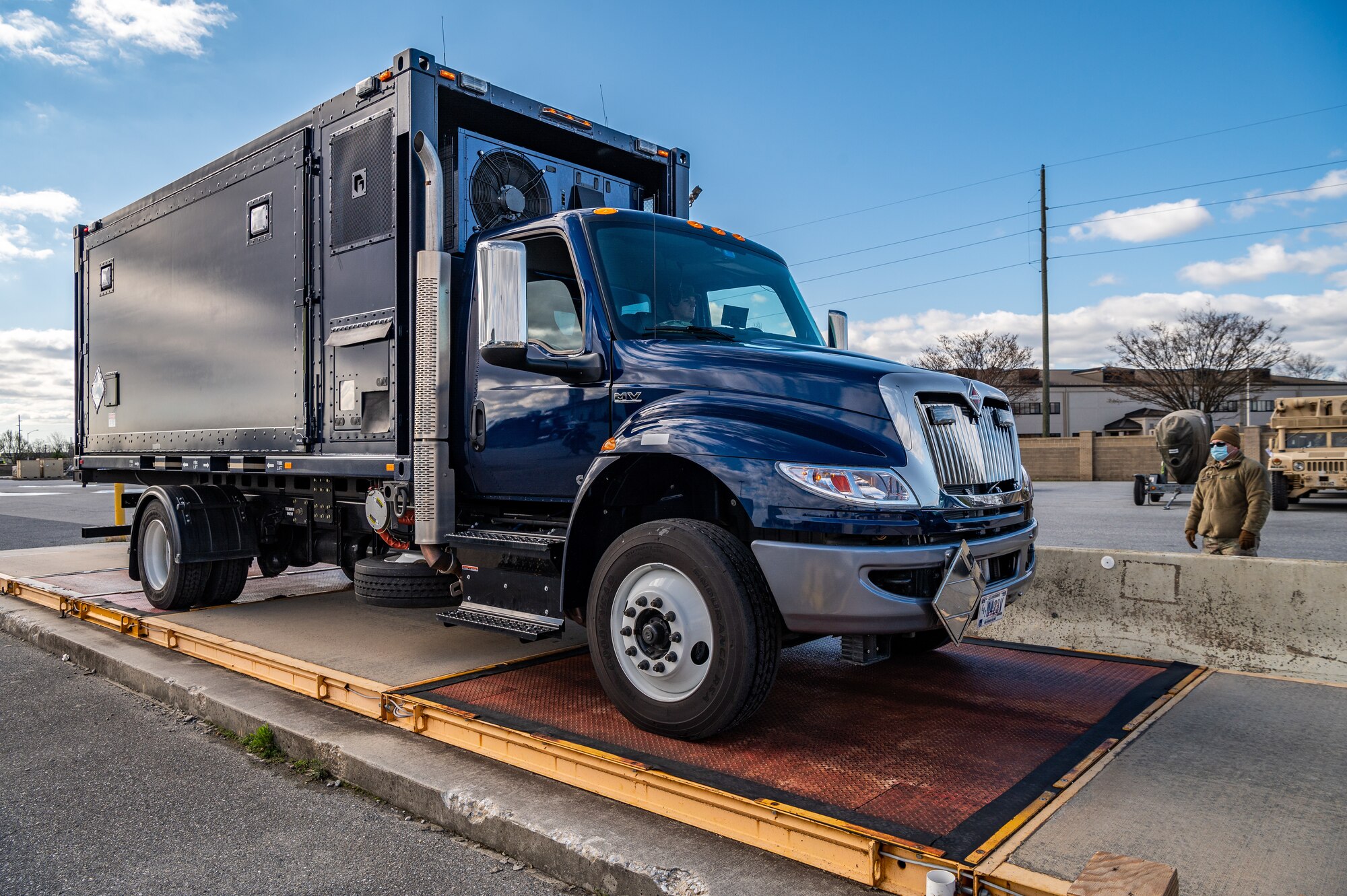 A Delaware Army National Guard truck is loaded onto a weighing scale during joint training at Dover Air Force Base, Delaware, March 29, 2021. The training focused on providing rapid global airlift through the integration of U.S. Air Force Airmen and Delaware National Guard Soldiers. (U.S. Air Force photo by Senior Airman Christopher Quail)