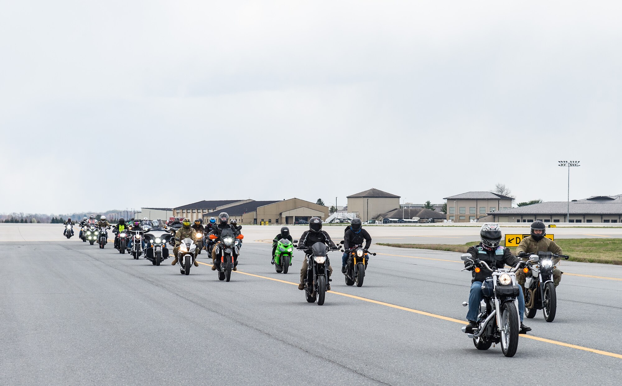 More than 20 motorcyclists ride down the taxiway on Dover Air Force Base, Delaware, April 2, 2021. The 436th Operations Support Squadron airfield manager led riders as part of Dover AFB’s motorcycle safety day. (U.S. Air Force photo by Roland Balik)