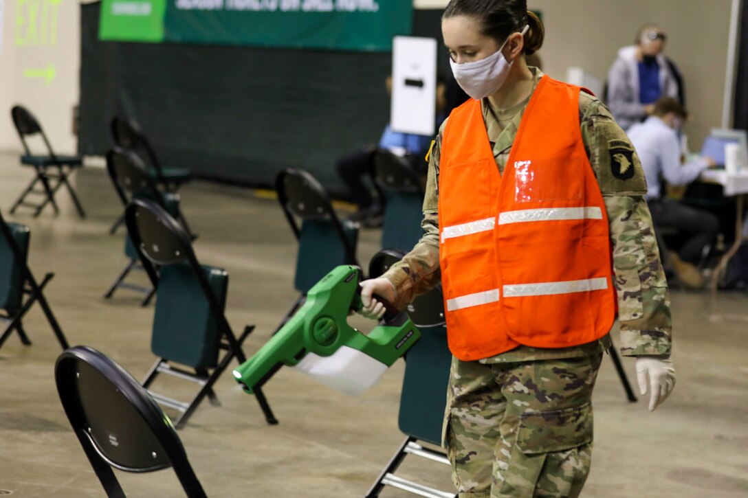 A solider sanitizes a chair.