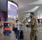 New York Army National Guard Spc. Enda Wang, a member of the 187th Signal Company, checks the phone of an international traveler arriving at John F Kennedy International Airport, New York, to ensure she completed the digital version of the New York State Travel Health form April 1, 2021. Between October 16 and April 1, New York National Guard personnel checked and collected over 3 million electronic and paper forms.