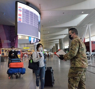 New York Army National Guard Spc. Enda Wang, a member of the 187th Signal Company, checks the phone of an international traveler arriving at John F Kennedy International Airport, New York, to ensure she completed the digital version of the New York State Travel Health form April 1, 2021. Between October 16 and April 1, New York National Guard personnel checked and collected over 3 million electronic and paper forms.