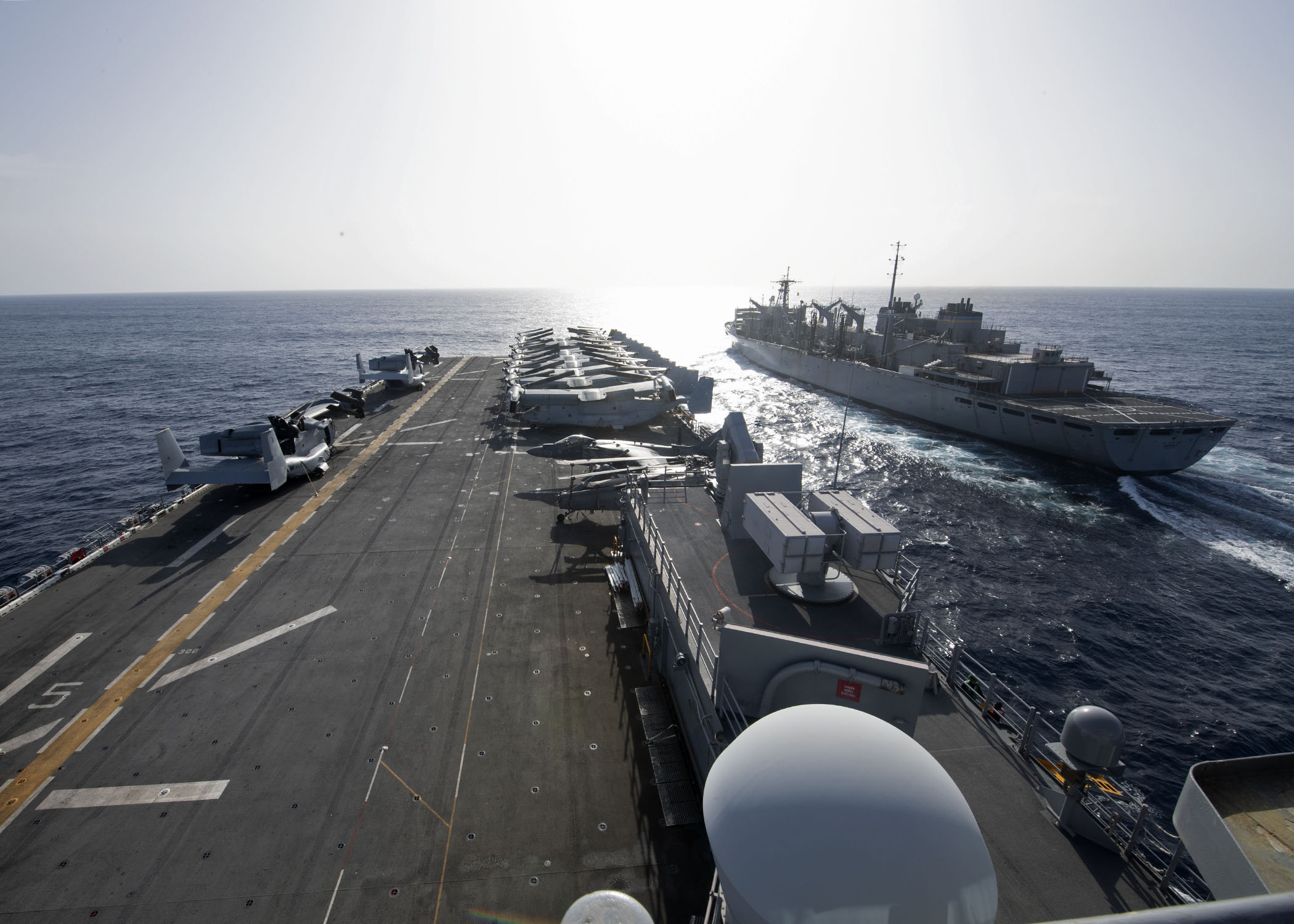 USS Iwo Jima (LHD 7), left, approaches the fast combat support ship USNS Supply (T-AOE 6) during a replenishment-at-sea, April 3, 2021.
