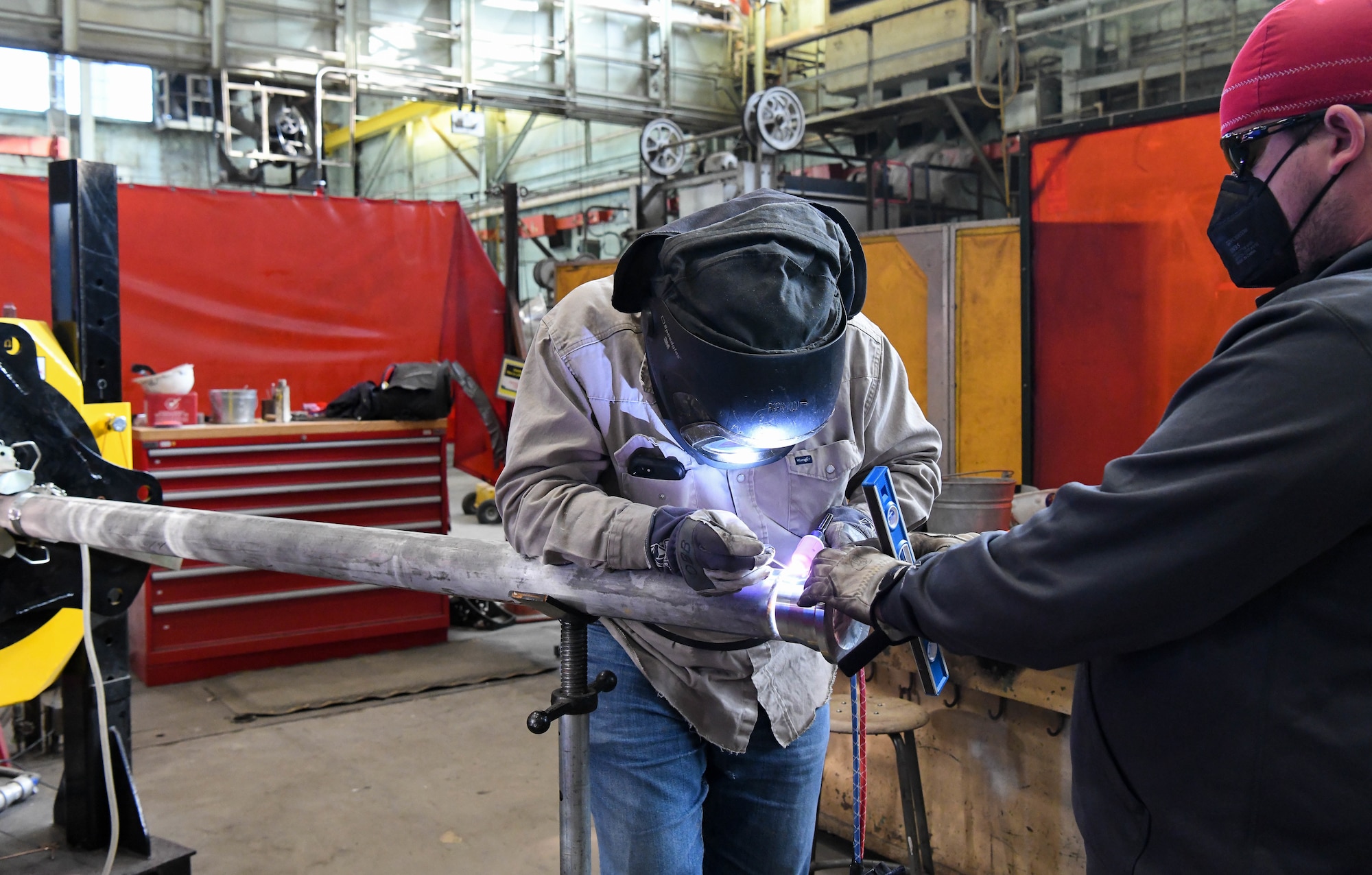 Dustin Williams, right, a pipefitter, holds a flange in place as fellow pipefitter Billy Joe Emberton places tack welds, March 4, 2021, at the Model Shop at Arnold Air Force Base, Tenn. April is National Welding Month. (U.S. Air Force photo by Jill Pickett)