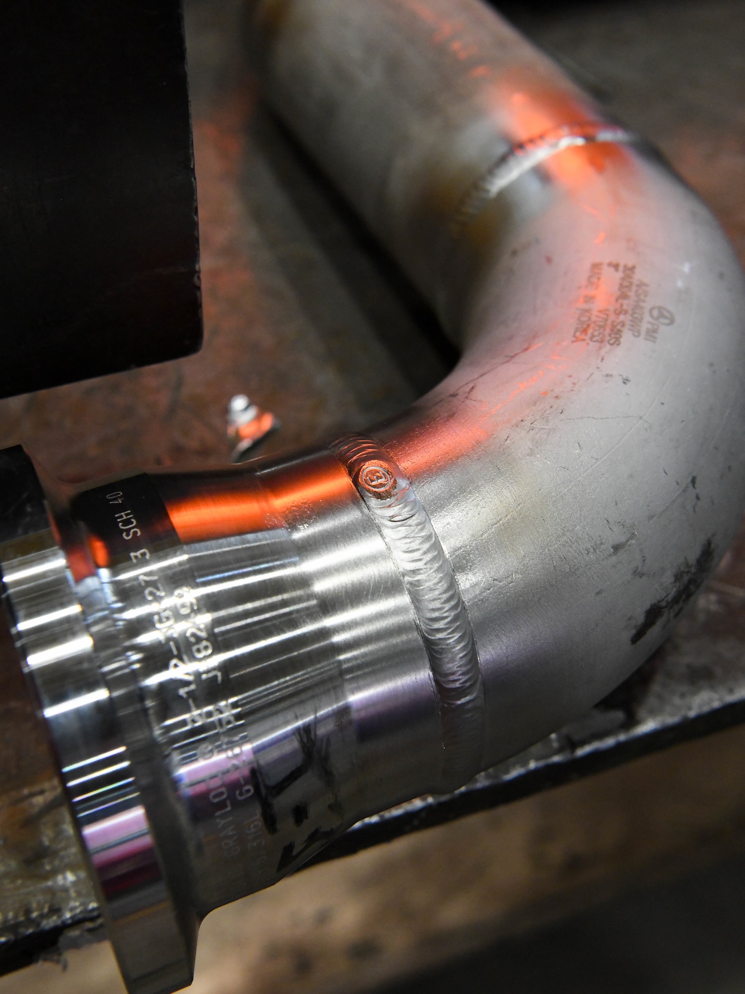 A weld completed by an Arnold Air Force Base craftsman secures a flange to a pipe elbow the Model Shop at Arnold Air Force Base, Tenn., March 4, 2021. April is National Welding Month. (U.S. Air Force photo by Jill Pickett)