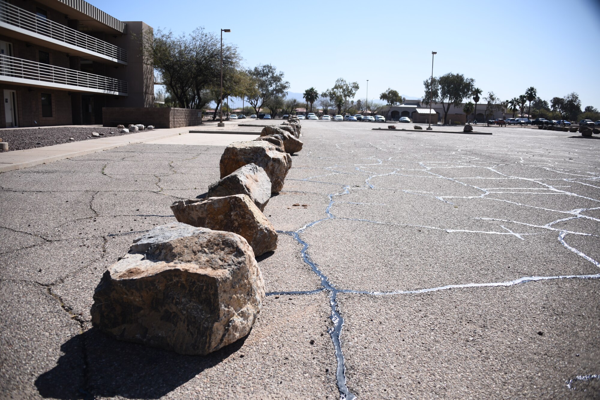 A line of boulders sit in font of a building.