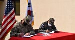 Col. Garrett Cottrell (left), Deputy Commanding Officer - Transformation, U.S. Army Corps of Engineers Far East District, and Col. Pyo In Tae (right), Chief, Program Management Team, ROK Design and Construction Agent, sign the Acceptance Release Letter for SPT060 Site 2 Building E, which will support storage requirements for various agencies across USAG Humphreys, Republic of Korea, Apr. 2, 2021.