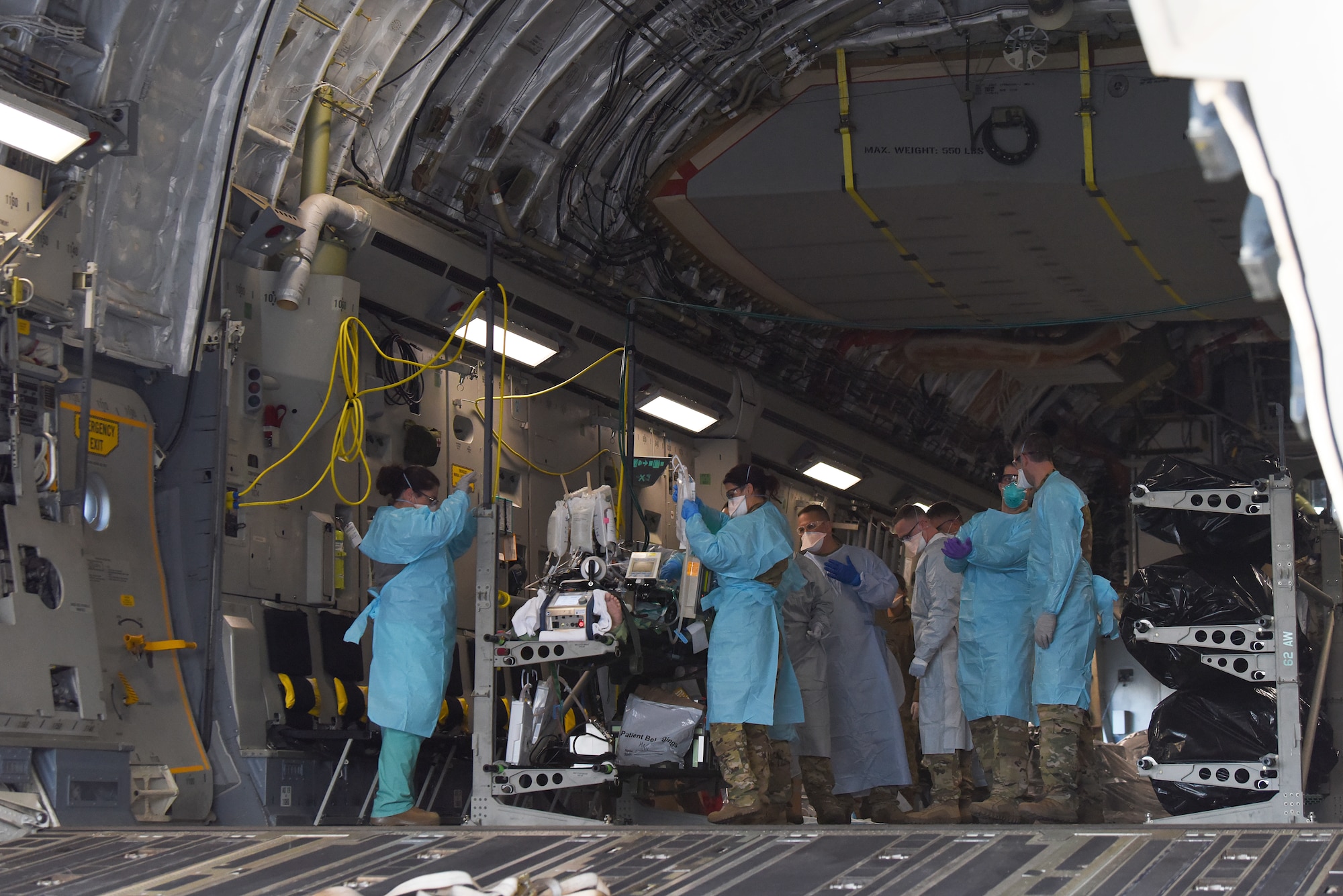 A COVID-19 patient who was being cared for at Madigan Army Medical Center, is loaded onto a C-17 Globemaster III by an aeromedical evacuation team from the 775th Expeditionary Aeromedical Evacuation flight from Travis Air Force Base, California, and other medical professionals from Madigan, at Joint Base Lewis-McChord, Washington, March 31, 2021. The patient was in severe respiratory distress and was hooked up to an extracorporeal membrane oxygenation (EMCO) system, which aids the body in breathing. (U.S. Air Force photo by Senior Airman Mikayla Heineck)