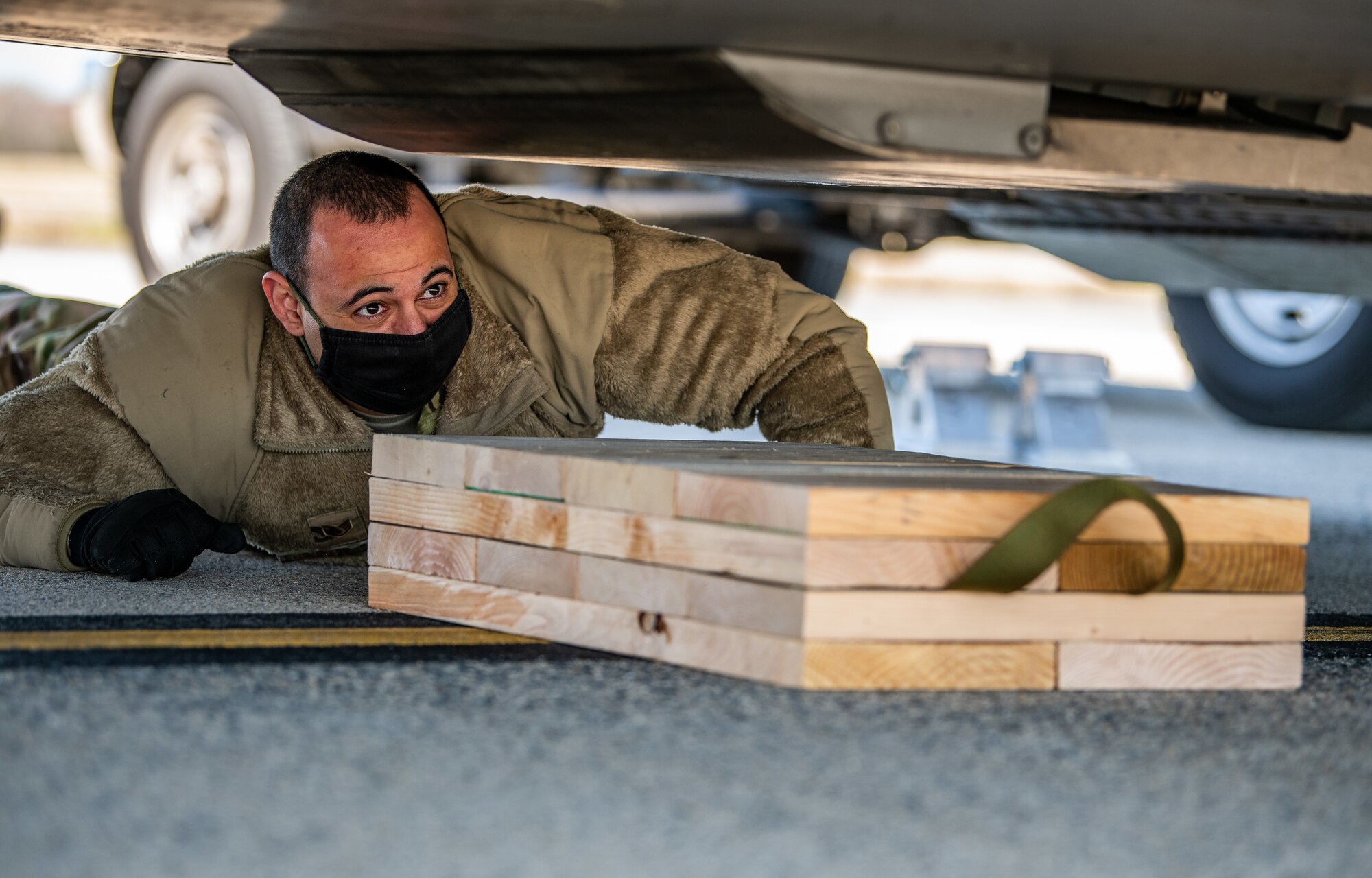 Staff Sgt. Jonathan Enriquez Colin, 3rd Airlift Squadron loadmaster, places wood shoring under a C-17 Globemaster III during joint training at Dover Air Force Base, Delaware, March 29, 2021. The training focused on providing rapid global airlift through the integration of U.S. Air Force Airmen and Delaware National Guard Soldiers. (U.S. Air Force photo by Senior Airman Christopher Quail)