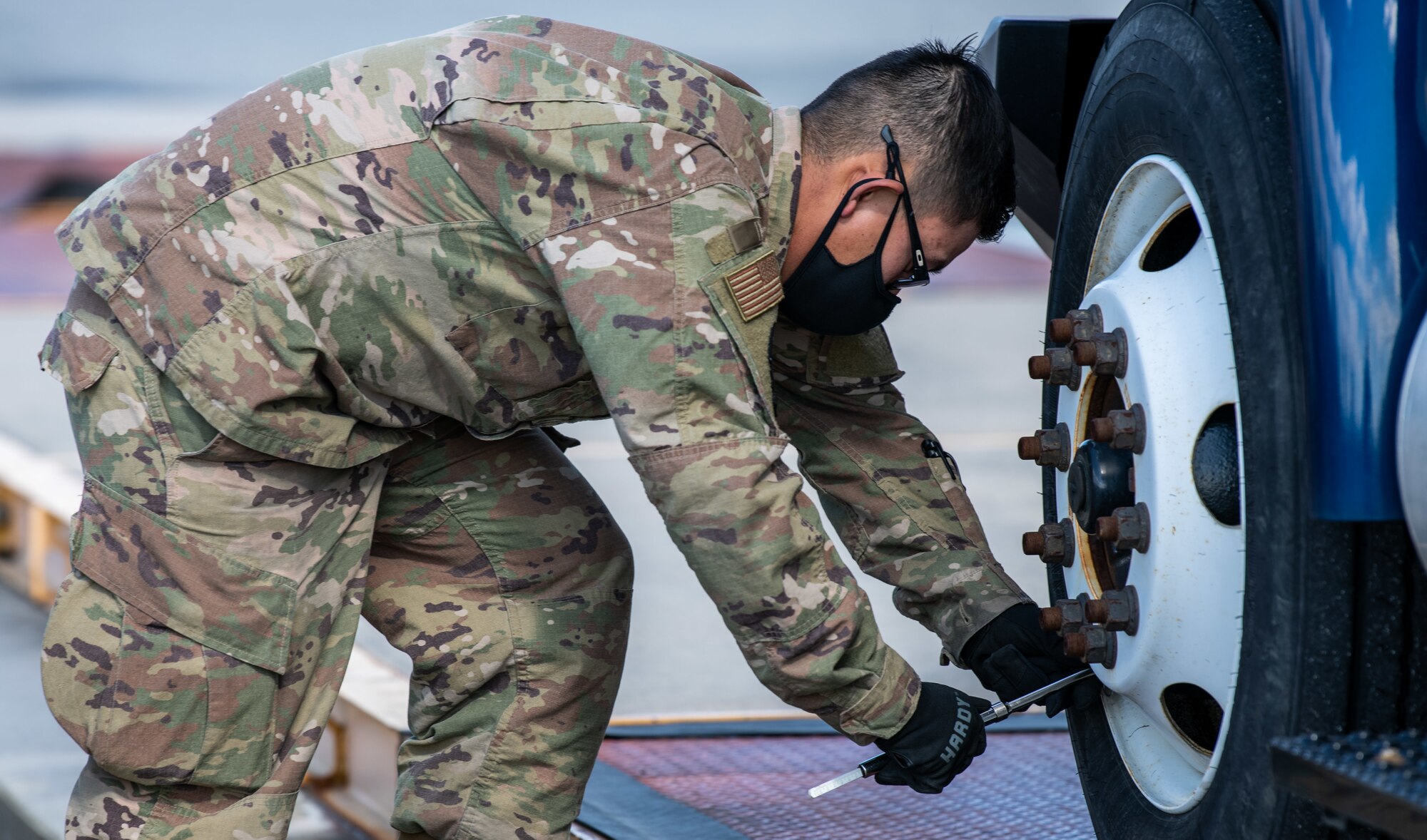 Tech. Sgt. Jimmy Tran, 56th Aerial Port Squadron air transportation specialist, checks the tire pressure of a Delaware Army National Guard truck during joint training at Dover Air Force Base, Delaware, March 29, 2021. The training focused on providing rapid global airlift through the integration of U.S. Air Force Airmen and Delaware National Guard Soldiers. (U.S. Air Force photo by Senior Airman Christopher Quail)
