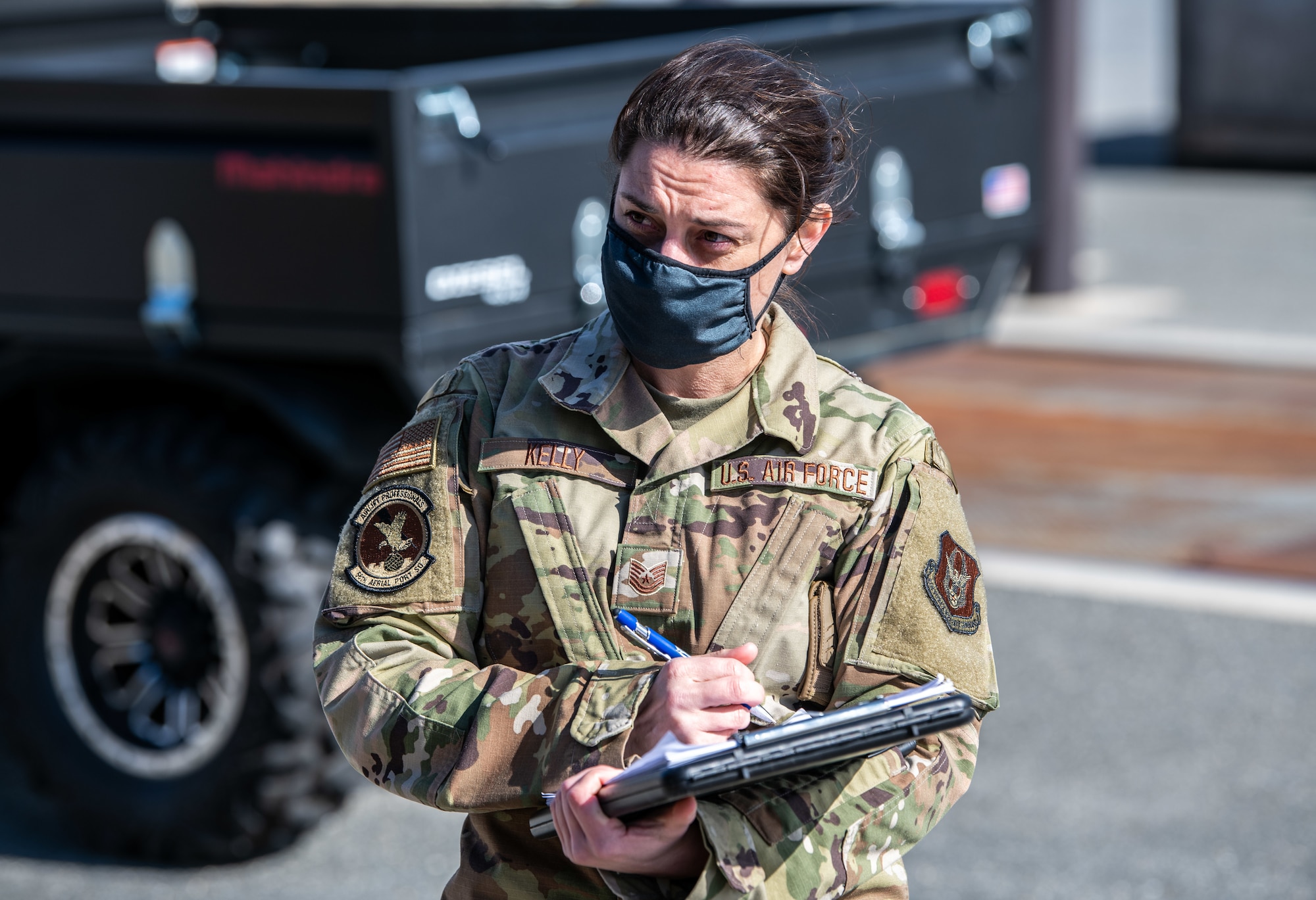 Tech. Sgt. Kristen Kelly, 56th Aerial Port Squadron special handling noncommissioned officer in charge, writes down weights and measurements of a Delaware Army National Guard truck during joint training at Dover Air Force Base, Delaware, March 29, 2021. The training focused on providing rapid global airlift through the integration of U.S. Air Force Airmen and Delaware National Guard Soldiers. (U.S. Air Force photo by Senior Airman Christopher Quail)
