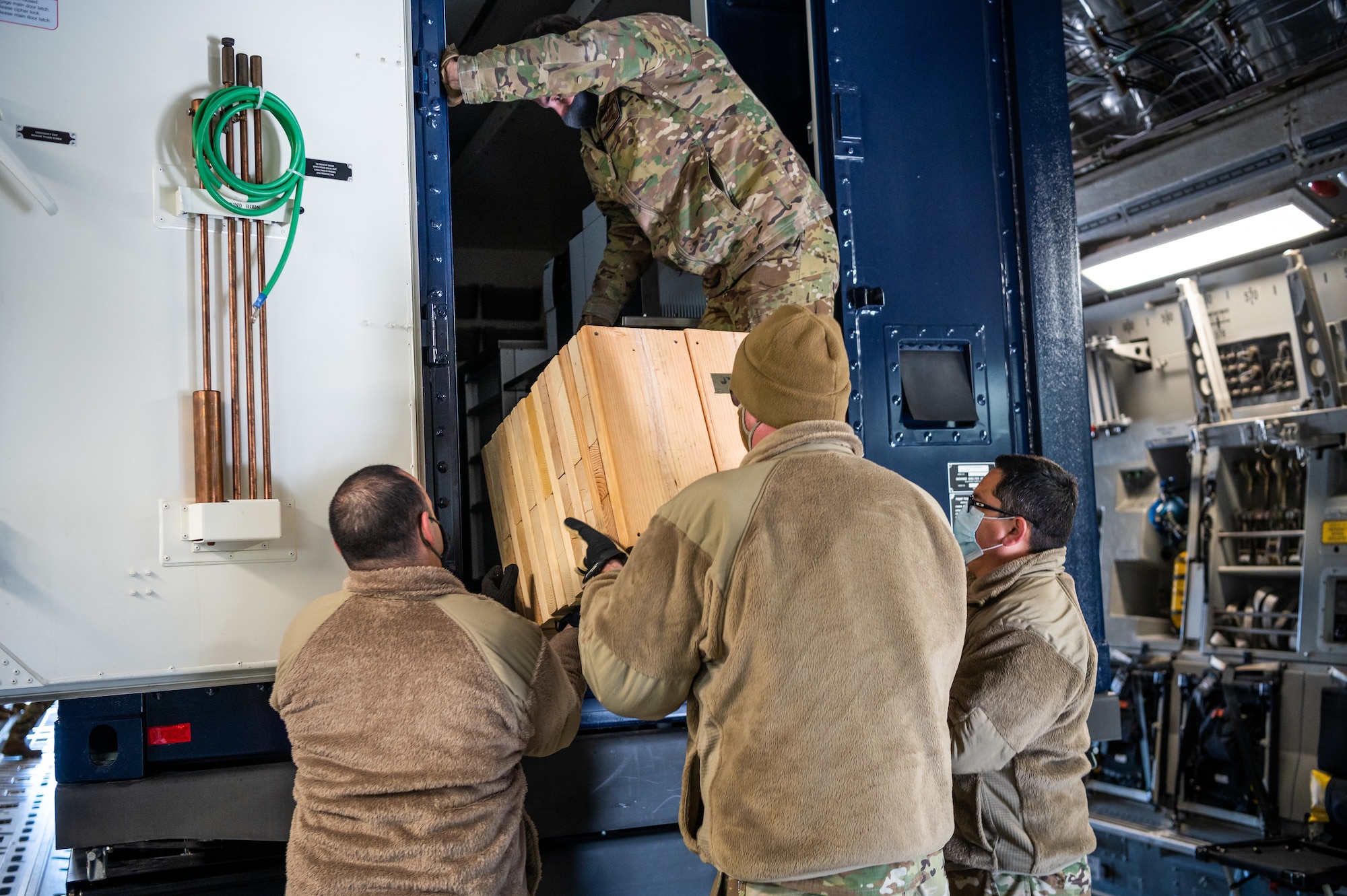 Airmen from the 3rd Airlift Squadron and Soldiers from the 31st Civil Support Squadron, Delaware Army National Guard, unload wood shoring during joint training at Dover Air Force Base, Delaware, March 29, 2021. The training focused on providing rapid global airlift through the integration of U.S. Air Force Airmen and Delaware National Guard Soldiers. (U.S. Air Force photo by Senior Airman Christopher Quail)