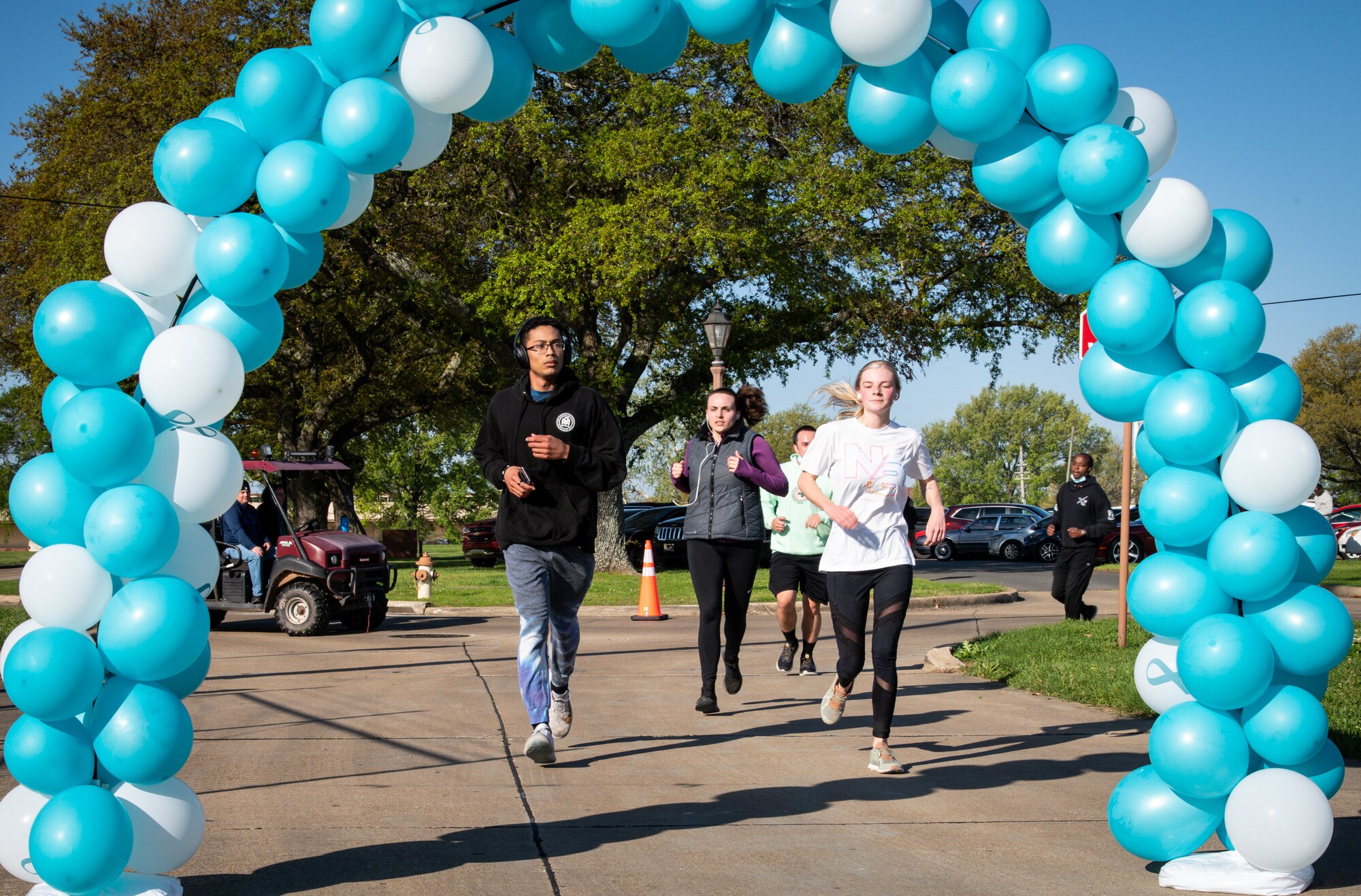 Participants in the Sexual Assault Awareness Month 5K run through the finish line at Barksdale Air Force Base, Louisiana, April 2, 2021.