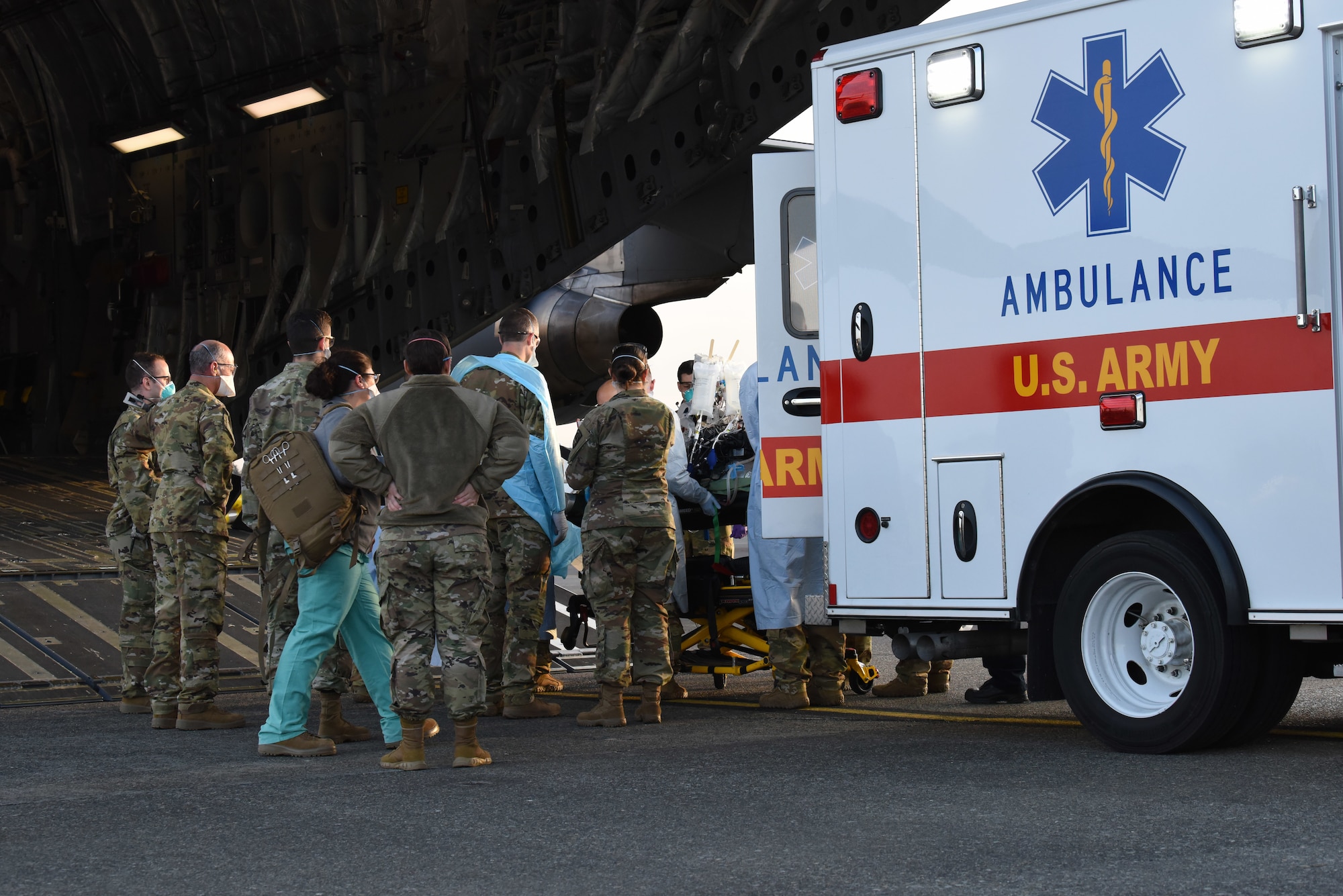 A COVID-19 patient who was being cared for at Madigan Army Medical Center is loaded onto a C-17 Globemaster III by an aeromedical evacuation team from the 775th Expeditionary Aeromedical Evacuation flight from Travis Air Force Base, California, and other medical professionals from Madigan, at Joint Base Lewis-McChord, Washington, March 31, 2021. The patient was in severe respiratory distress and was hooked up to an extracorporeal membrane oxygenation (EMCO) system, which aids the body in breathing. (U.S. Air Force photo by Senior Airman Mikayla Heineck)