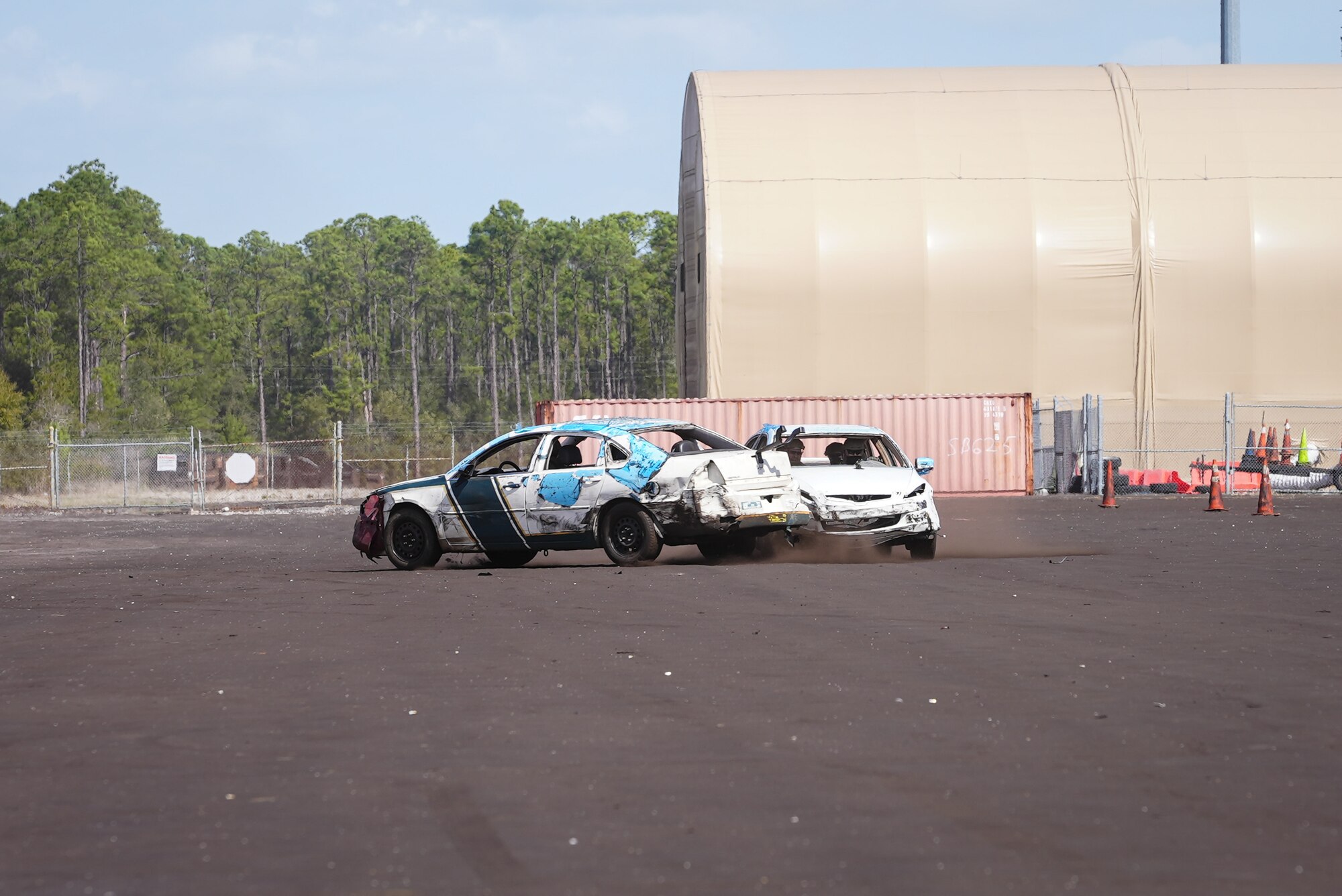 Two cars kick up dust off of runway as they collide.