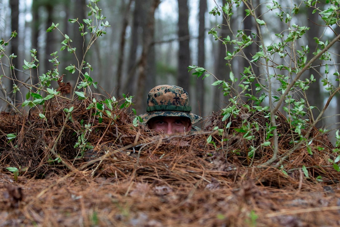 U.S. Marine Corps Capt. Travis Bird, an infantry officer with 1st Battalion, 6th Marine Regiment, 2d Marine Division, lays in a fighting position during a Division Leaders Assessment Program (DLAP) at Fort Pickett, V.A., March 28, 2021. The program prepares Marine Corps captains with the ability, proficiency and skills of becoming infantry company commanders. This is a pilot iteration to refine the schedule of events, processes and procedures that will be used to evaluate inbound infantry captains for company command. (U.S. Marine Corps photo by Pfc. Sarah Pysher)