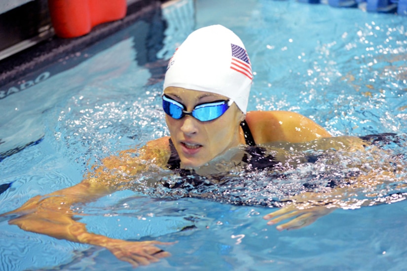 A soldier swims in a pool.