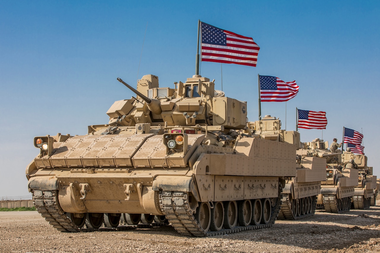 Tanks move through the desert.