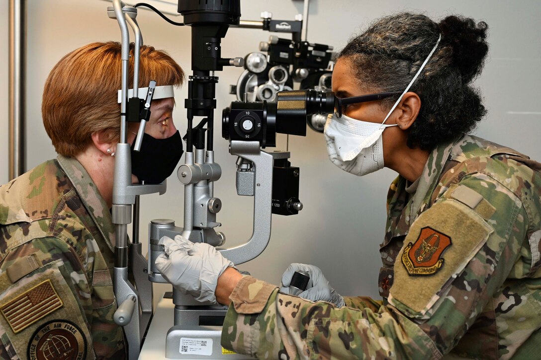 An airmen receives an eye exam from a fellow airmen.