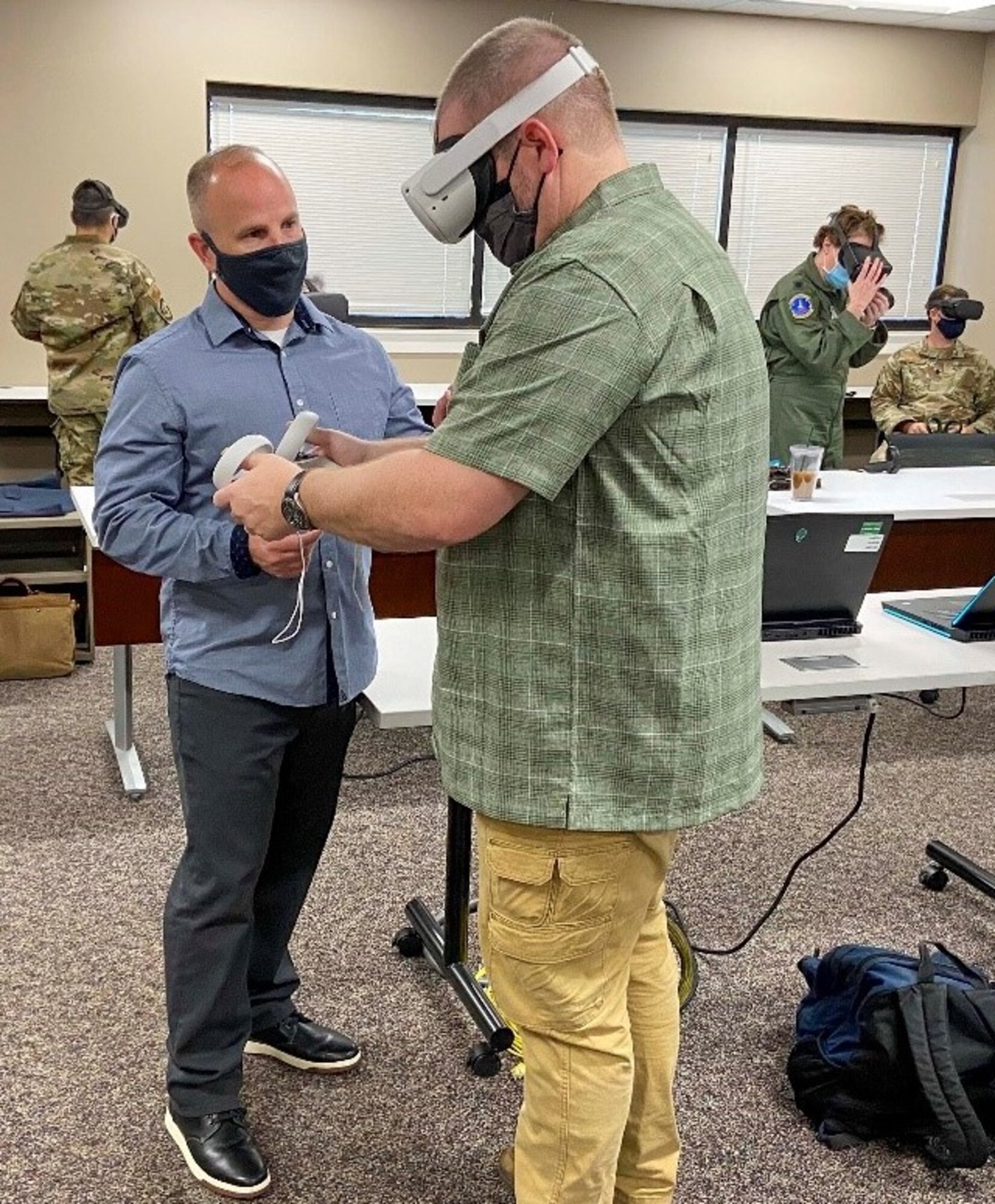 Dr. Andy Clayton, an assistant professor of leadership and augmented reality/virtual reality research task force director, helps a Regional Security Studies student during a VR trip to South America at Maxwell Air Force Base, Alabama, Mar. 29, 2021. This type of immersive learning helps students retain information from their VR experience and allows them to interact with curriculum content.