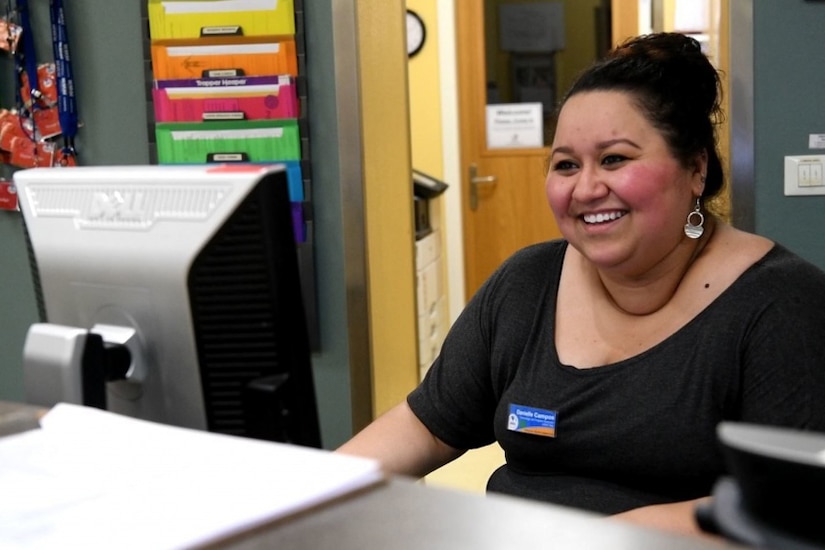 A woman sits at a computer.