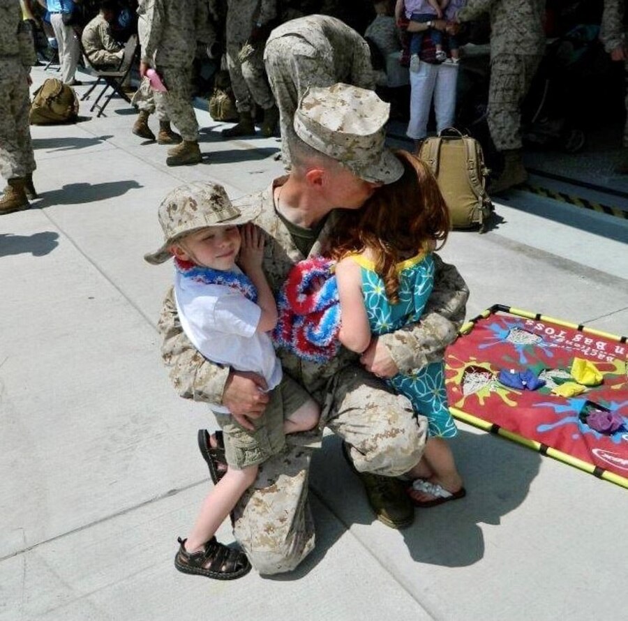U.S. Marine Corps Col. Mikel Huber, commanding officer of Marine Corps Air Station (MCAS) Cherry Point, North Carolina, greets his children upon return from a deployment to Afghanistan. Mikel and his wife, retired U.S. Navy Cmdr. Alana Huber, former Director of Public Health and Warfighter Organization at Naval Health Clinic Cherry Point, both experienced extended separations from family to fulfill service obligations, on the way to making their dual-active duty military relationship work. (Courtesy photo provided by U.S. Marine Corps Col. Mikel Huber)