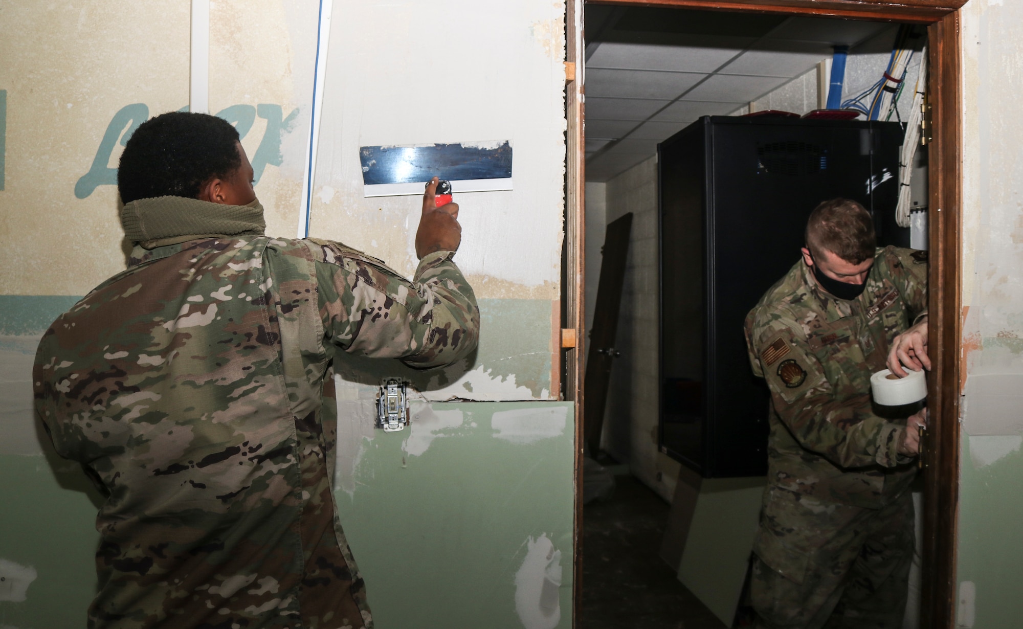 Staff Sgt. Alex Simon, 60th Civil Engineer Squadron heating, ventilation and air conditioning technician, left, lays joint compound as Tech. Sgt. Jason Goss, 28th CES structural craftsman, right, puts a layer of tape and drywall compound on walls in a 7th Logistical Readiness Squadron building floor at Dyess Air Force Base, Texas, Mar. 9, 2021. Airmen with CES’s from multiple bases helped with building repairs from winter weather damage. (U.S. Air Force photo by Staff Sgt. David Owsianka)