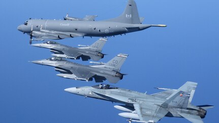 A Royal Canadian Air Force CP-140 long range patrol aircraft flies in formation with two U.S. Air Force F-16s and a RCAF CF-18.