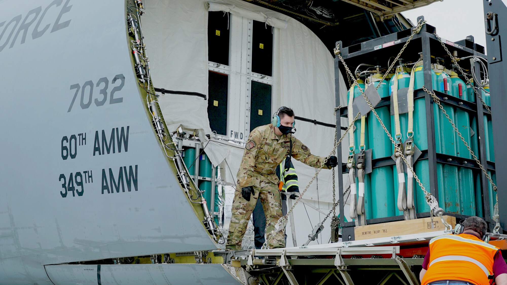 Senior Airman Mathew Roth, 22nd Airlift Squadron C-5M Super Galaxy aircraft loadmaster from Travis Air Force Base, Calif., guides a forklift operator loading gas tanks during transport operations at Moffett Federal Airfield, Calif., Mar. 17, 2021. The C-5M Super Galaxy transported the U.S. Space Force’s Space and Missile Systems Center's SBIRS GEO-5 satellite, part of a missile warning constellation for national defense, to Cape Canaveral for it’s launch later this year.(U.S. Space Force photo by Walter Talens)