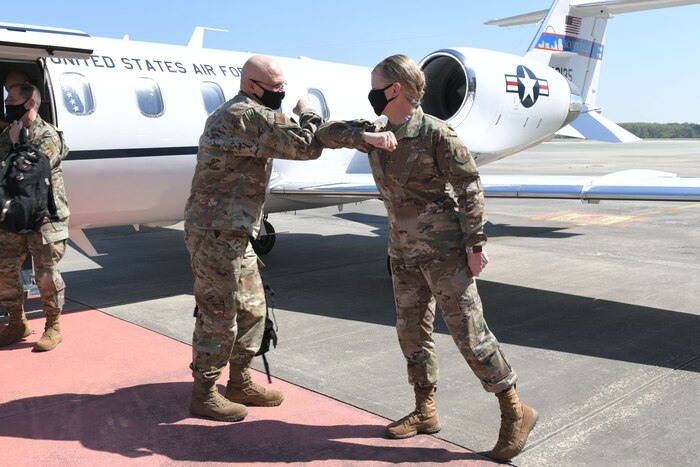 Photo shows the generals elbow bumping on the flight line.