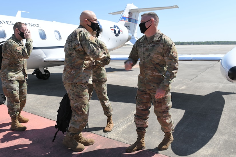 Photo shows two meet going to elbow bump on the flight line.