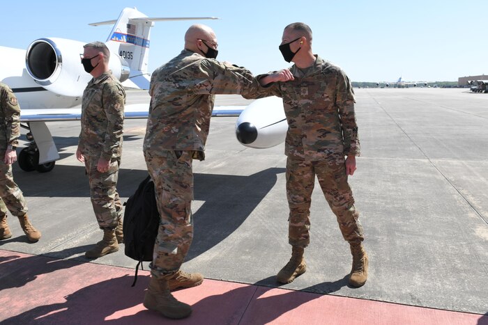 Photo shows the general bumping elbows with the chief on the flight line.