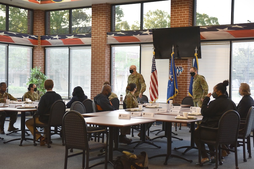 Photo shows the team walking to their seats at the front of a group of tables with Airmen seated throughout the room.