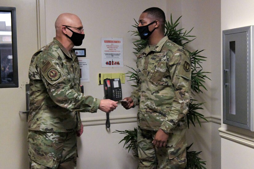 Photo shows the two exchanging a coin in an entryway.