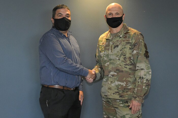 Photo shows the two exchanging a coin in a hallway.