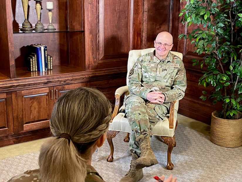 Photo shows general sitting in a chair facing the capitan.