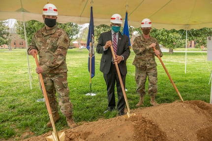 three people stop for a photo during a ground breaking ceremony