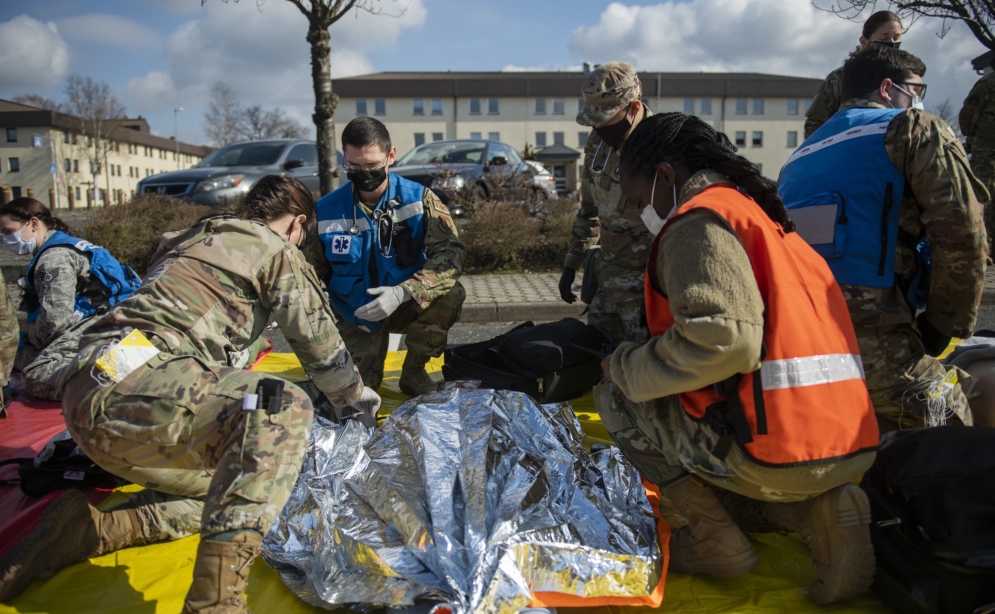 A volunteer for the 52nd Medical Group exercise Ready EAGLE lies on a tarp while receiving simulated medical attention by MDG Airmen at Spangdahlem Air Base, Germany, March 26, 2021. During the simulated disaster response exercise, Wing Inspection Team members assessed the performance of Airmen and read off scenario cards to better help the team understand patient injuries. (U.S. Air Force photo by Senior Airman Ali Stewart)