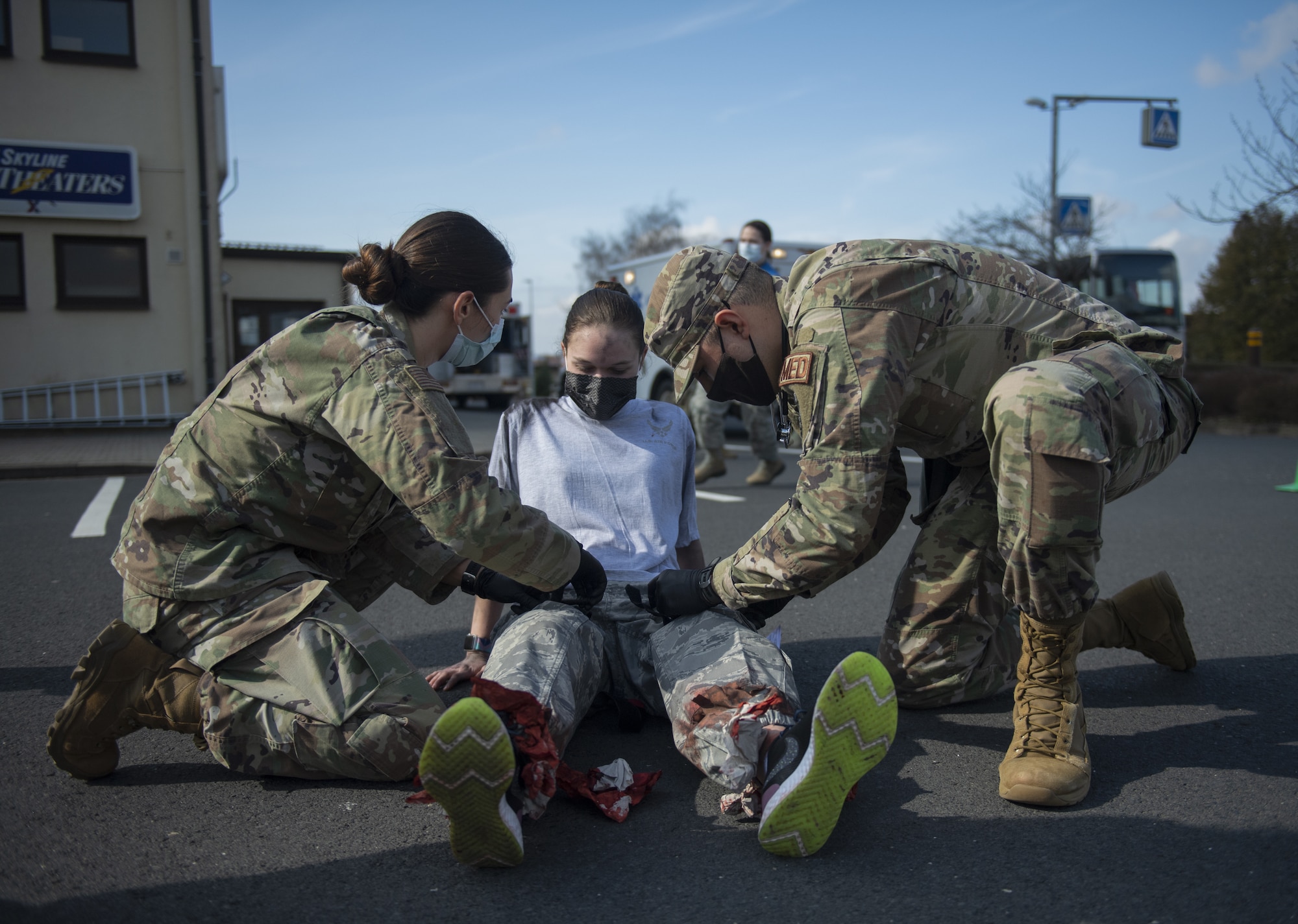 Two U.S. Air Force Airmen from the 52nd Medical Group tend to a volunteer after a simulated disaster inside the base theater at Spangdahlem Air Base, Germany, March 26, 2021. The exercise allowed Airmen to hone disaster response skills such as command and control, patient stabilization and patient decontamination. (U.S. Air Force photo by Senior Airman Ali Stewart)