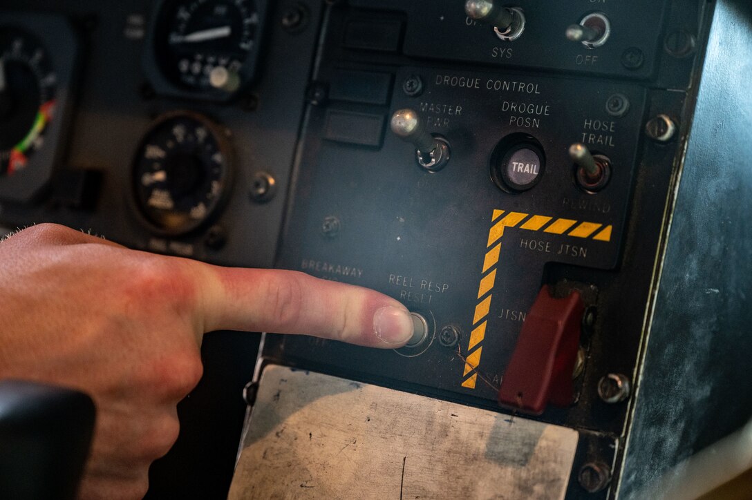 Tech. Sgt. Andrew Leaver pushes a button to retract the aircraft’s drogue.