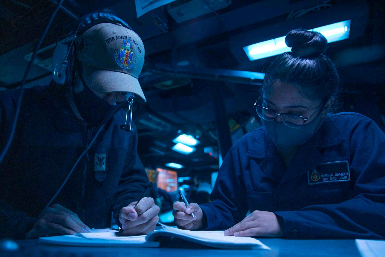210407-N-HI376-1004 SOUTH CHINA SEA (April 7, 2021) Operations Specialist 2nd Class Tyler Manning, from Orlando, Fla., and Operations Specialist Seaman Korina Damian, from Lake Havasu, Ariz., stand watch in the combat information center as the Arleigh Burke-class guided-missile destroyer USS John S. McCain (DDG 56) conducts routine underway operations. John S. McCain is forward-deployed to the U.S. 7th Fleet area of operations in support of a free and open Indo-Pacific. (U.S. Navy photo by Mass Communication Specialist 1st Class Jeremy Graham)