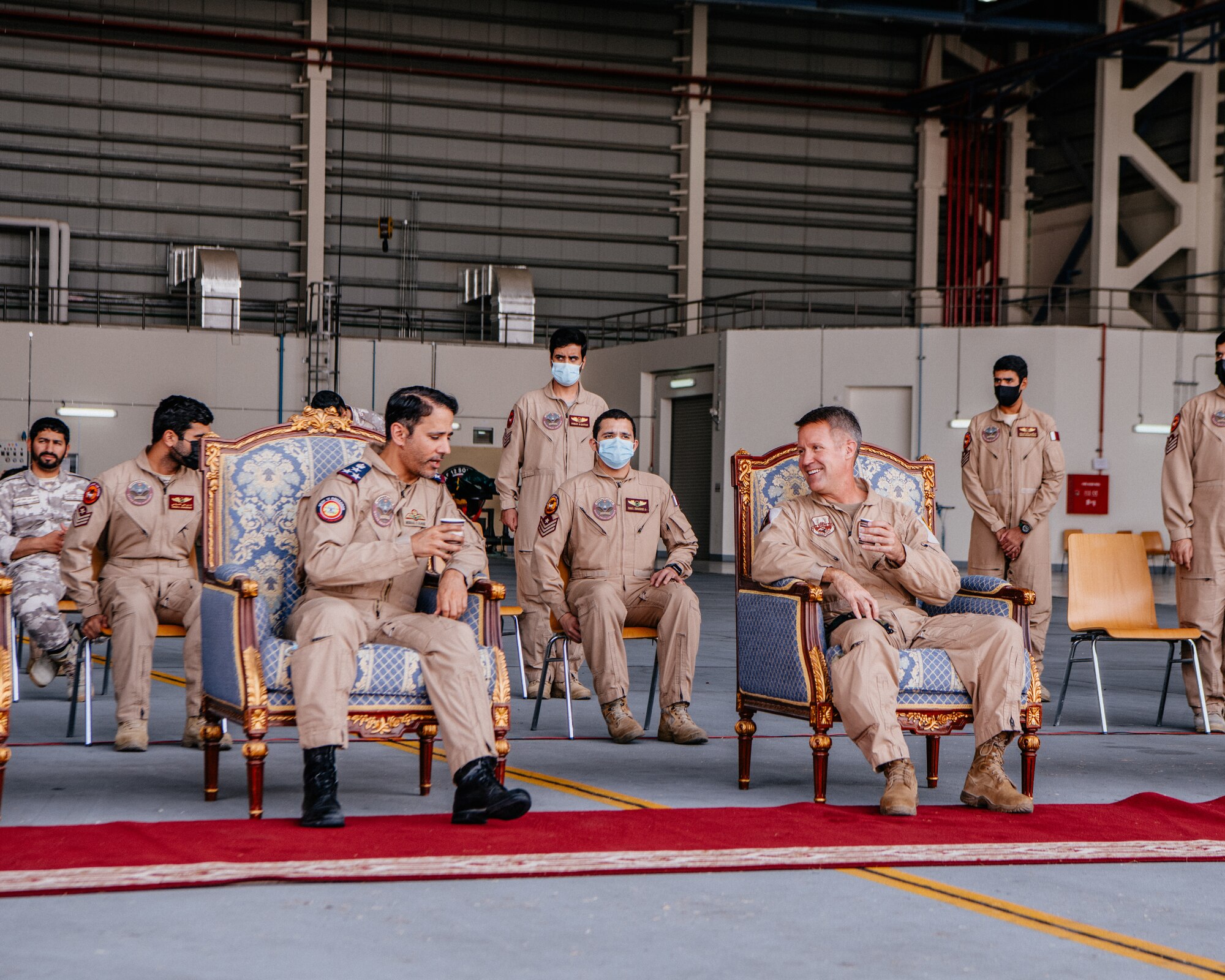 men sit in chairs speaking