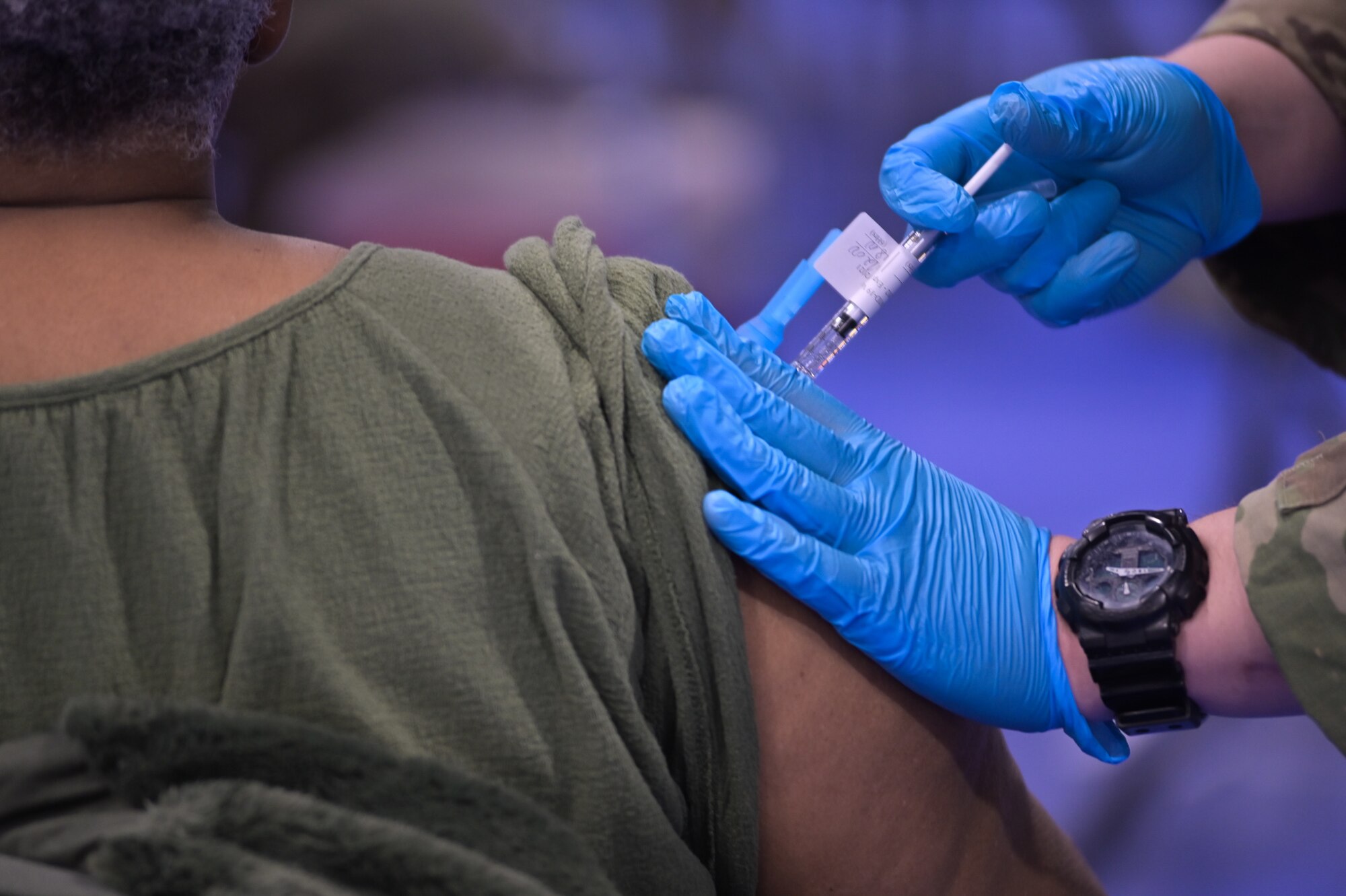 U.S. Army, Illinois National Guard combat medic administers COVID-19 vaccine to a patient in the South Suburban College gym, South Holland, Illinois, February 25, 2021. The gym is one of many vaccine administration sites located throughout Illinois.
